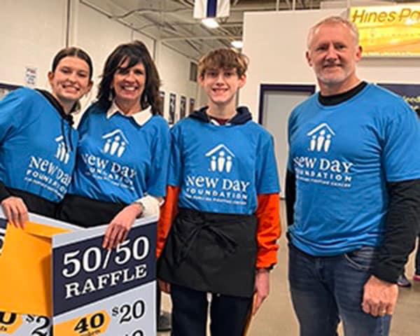 Four volunteers wearing New Day t-shirts